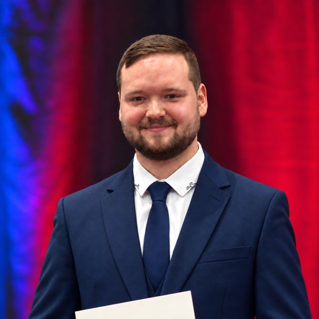 Porträt von Arthur Hardy Kotsch (B.Eng.) im Anzug bei der Abschlussfeier der Dualen Hochschule Sachsen