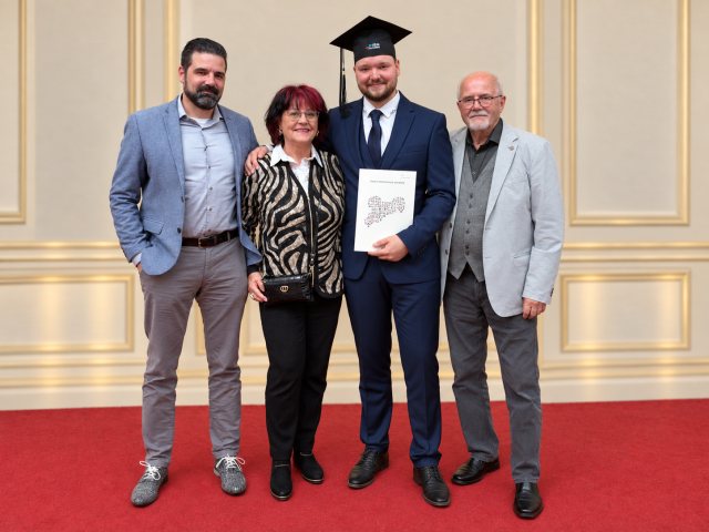 Hardy Kotsch, Gudrun Kotsch, Arthur Hardy Kotsch mit DHSN-Alumni-Kappe und Jürgen Kotsch bei der Abschlussfeier der Dualen Hochschule Sachsen